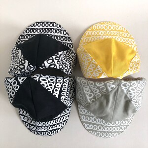 May include: Three cycling caps with a black and white chain link pattern. The caps are made of a soft, breathable fabric and have a comfortable fit. The caps are available in black, yellow, and gray.