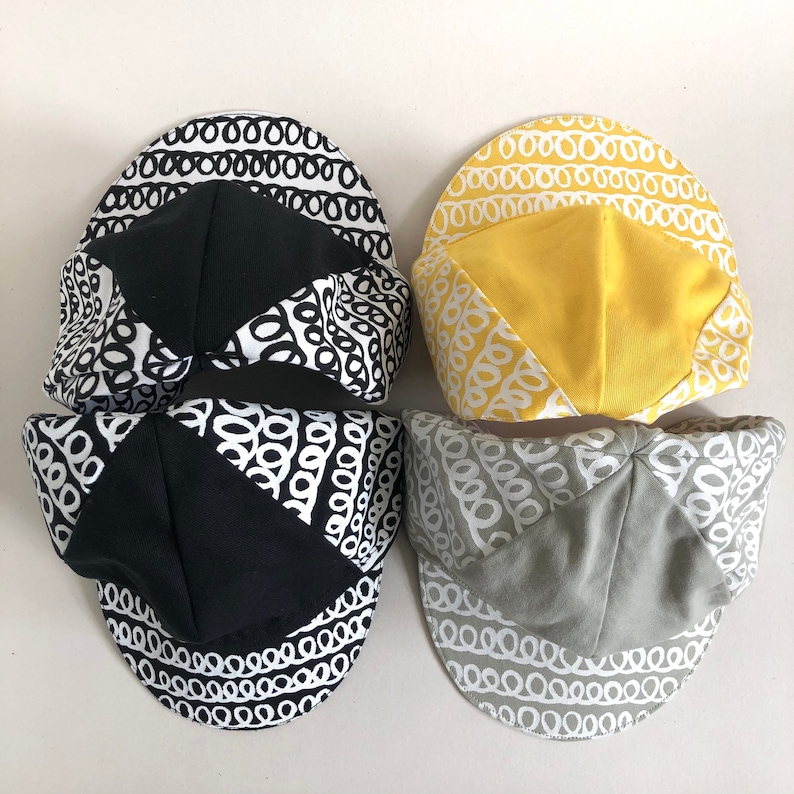 May include: Three cycling caps with a black and white chain link pattern. The caps are made of a soft, breathable fabric and have a comfortable fit. The caps are available in black, yellow, and gray.