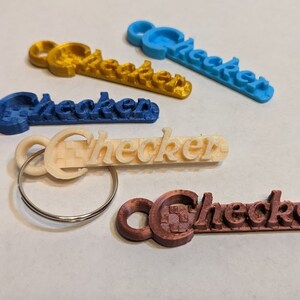 May include: Five keychains with the word "Checker" printed on them. The keychains are in different colors: blue, gold, beige, brown, and light blue.