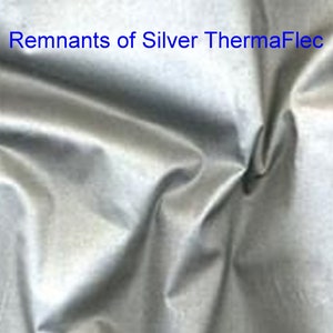 K&ouml;nnte beinhalten: Silberner Stoff mit metallischem Glanz, gefaltet und zerknittert. Reste von Silver ThermaFlec.