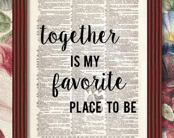 May include: A framed print with a vintage dictionary page background. The text "together is my favorite place to be" is printed in black on the page.