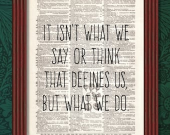 May include: A framed print with a black and white vintage dictionary page background. The quote "It isn't what we say or think that defines us, but what we do." is printed in black text.