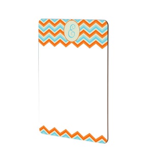 May include: A white dry erase board with a chevron pattern border in orange and blue. The top border has a circle with the letter "E" in blue.