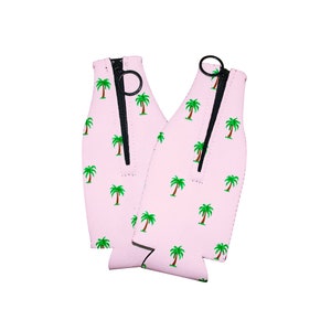 May include: Two pink neoprene can coolers with a zipper closure and a palm tree print.