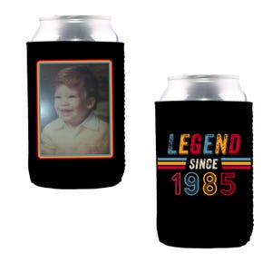 Pu&ograve; includere: Due refrigeratori per lattine neri. Un refrigeratore presenta una foto di un bambino piccolo con il testo "Legend Since 1985". L'altro refrigeratore ha il testo "Legend Since 1985" in lettere retr&ograve; colorate.