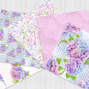 Pu&ograve; includere: Quattro fogli di carta con motivi diversi che presentano ortensie ad acquerello in tonalit&agrave; di viola, blu e rosa. I motivi includono un damasco floreale, un motivo a righe e un foglio rosa con testo scritto a mano.