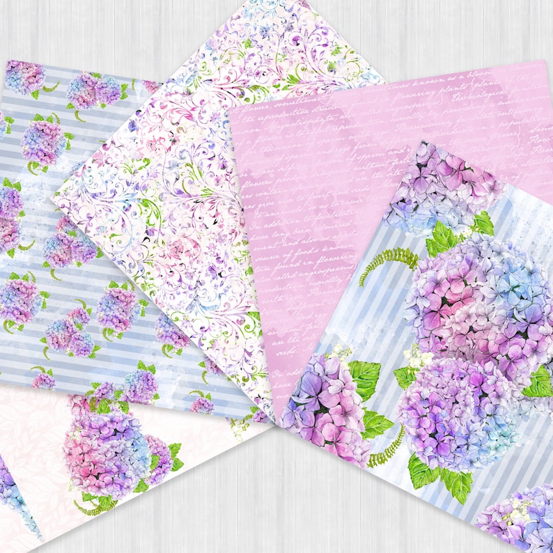 Pu&ograve; includere: Quattro fogli di carta con motivi diversi che presentano ortensie ad acquerello in tonalit&agrave; di viola, blu e rosa. I motivi includono un damasco floreale, un motivo a righe e un foglio rosa con testo scritto a mano.