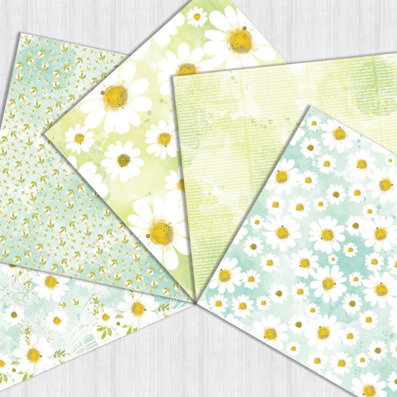 May include: Five different patterned papers with a watercolor background and white daisies. The papers are in a fan shape and have a light green, blue, and white color scheme.