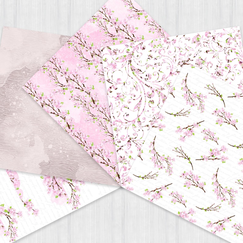 Puede incluir: Cuatro hojas de papel con diferentes patrones con dise&ntilde;os florales rosas y blancos. Los papeles est&aacute;n dispuestos en forma de abanico sobre un fondo de madera clara.