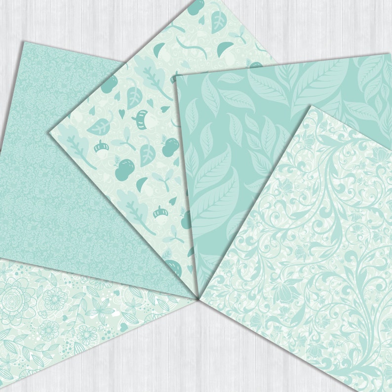 May include: Six different patterned scrapbook paper sheets in various shades of light blue and white. The patterns include leaves, flowers, and swirls.