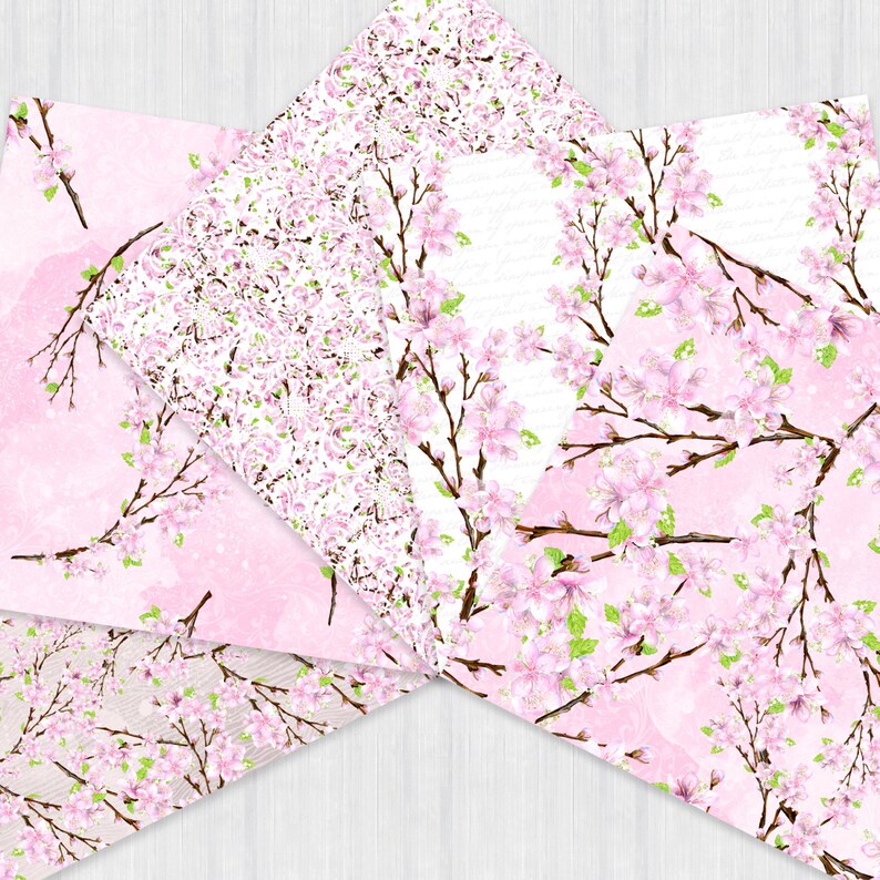Puede incluir: Cuatro papeles estampados diferentes, rosa y blanco, con un dise&ntilde;o floral que presenta flores de cerezo rosas y hojas verdes. Los papeles est&aacute;n dispuestos en forma de estrella.