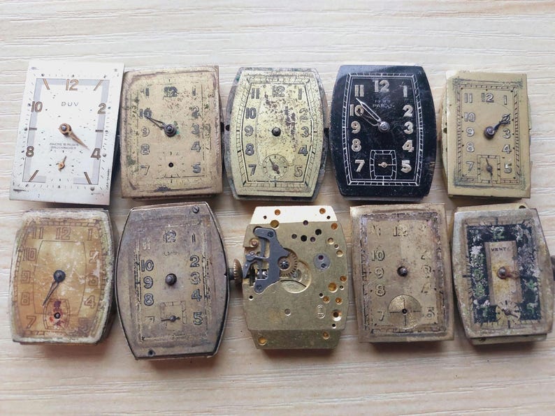 Puede incluir: Una colecci&oacute;n de diez esferas y mecanismos de relojes antiguos. Las esferas var&iacute;an en forma y color, incluyendo dise&ntilde;os rectangulares, ovalados y cuadrados. Algunas tienen n&uacute;meros y manecillas visibles, mientras que otras muestran signos de edad y desgaste. Los colores van del crema al negro.