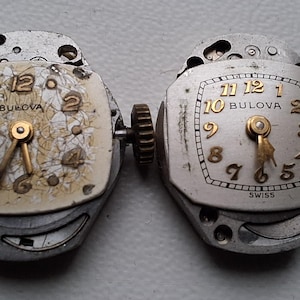 Peut inclure: Deux mouvements de montre Bulova vintage. L'un a un cadran cr&egrave;me avec des aiguilles et des chiffres dor&eacute;s, l'autre a un cadran argent&eacute; avec des aiguilles et des chiffres dor&eacute;s. Les deux ont le logo Bulova et sont de fabrication suisse.