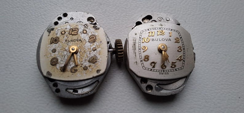 Peut inclure: Deux mouvements de montre Bulova vintage. L'un a un cadran cr&egrave;me avec des aiguilles et des chiffres dor&eacute;s, l'autre a un cadran argent&eacute; avec des aiguilles et des chiffres dor&eacute;s. Les deux ont le logo Bulova et sont de fabrication suisse.