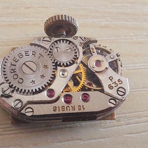 May include: A handmade, wooden cutting board with a natural finish. The board features a live edge on one side and a smooth, rectangular shape. It is approximately 18 inches long and 12 inches wide.