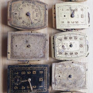 Puede incluir: Colecci&oacute;n de esferas de reloj antiguas de varias formas y tama&ntilde;os. Las esferas est&aacute;n envejecidas con desgaste visible, con n&uacute;meros romanos y delicadas manecillas. La paleta de colores incluye tonos crema, dorado y negro.