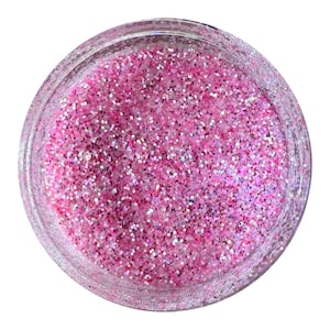 May include: A small glass jar filled with pink glitter. The glitter is iridescent and has a variety of sizes.