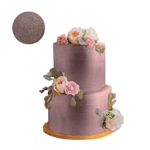 May include: Two-tiered wedding cake decorated with blush pink fondant and fresh flowers. The cake is on a wooden cake stand.