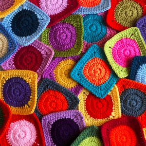 Puede incluir: Una colección de cuadrados de ganchillo coloridos con un patrón circular en el centro. Los cuadrados están hechos en varios colores, incluyendo rojo, naranja, amarillo, verde, azul, morado y rosa.