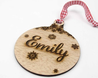 Adorno navideño personalizado de madera para el árbol con nombre grabado y copos de nieve