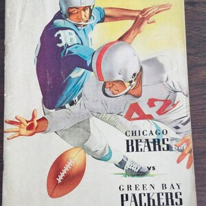 May include: Vintage football program cover featuring two players in action. One player wears a blue uniform with the number 38, the other a gray uniform with the number 42. The Chicago Bears vs Green Bay Packers game is advertised.