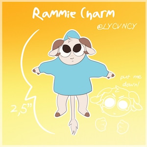 Könnte beinhalten: Eine Cartoon-Illustration eines weißen Widders mit braunen Hörnern, der einen hellblauen Hoodie trägt. Der Widder steht auf seinen Hinterbeinen, die Vorderbeine sind ausgestreckt. Der Widder ist 2,5 Zoll groß. Der Text "Rammie Charm" und "@LYCVNCY" steht über dem Widder. Der Text "put me down!" steht in der rechten unteren Ecke des Bildes.