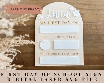 May include: A wooden sign with a white arch and the text "Luna" and "My First Day Of". The sign has blank spaces for the child's age, teacher's name, and future career. The sign is decorated with white flowers.