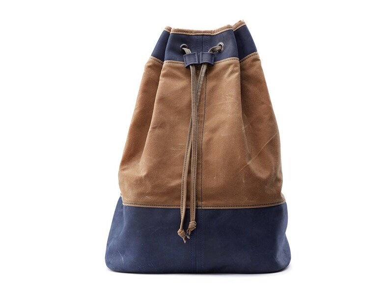 May include: A brown and blue canvas drawstring backpack with a long, adjustable drawstring.
