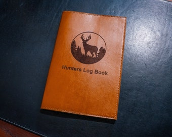 May include: A brown leather-bound journal with the text "Hunters Log Book" and a silhouette of a deer in a circle.