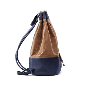 May include: A brown and blue canvas drawstring backpack with adjustable straps.