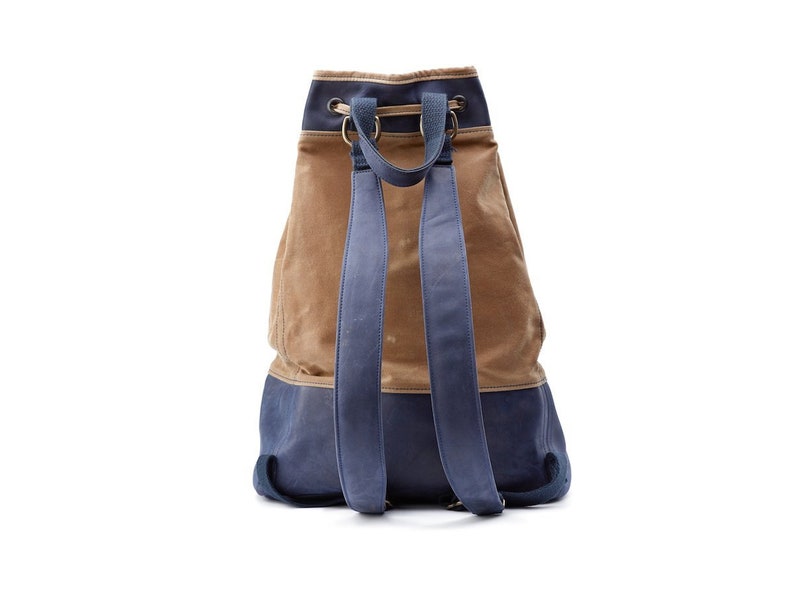 May include: A brown and blue canvas backpack with a drawstring closure and adjustable straps.