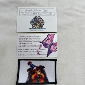 May include: Two rectangular white business cards and one rectangular embroidered patch. The top card features a German Shepherd in a paw print with the text Paws-A-Tive Touch. The middle card shows a pink butterfly and lists various pet products. The bottom patch displays a collie wearing a patriotic party hat.