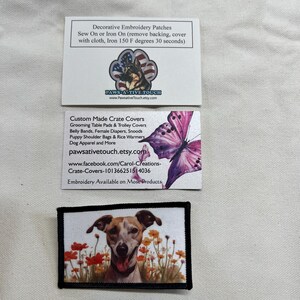 May include: Two rectangular white business cards and one rectangular embroidered patch. The top card features a German Shepherd logo and text about embroidery patches. The middle card shows a purple butterfly and business details. The bottom patch displays a brown and white dog in a field of orange flowers.
