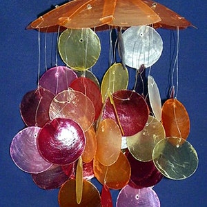 May include: A colorful wind chime made of iridescent seashells hanging from a brown, translucent umbrella-shaped top. The shells are in shades of pink, red, orange, and yellow.