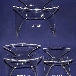 May include: Three clear acrylic display stands in different sizes: large, medium, and small. The stands are designed to hold items like books, magazines, or other decorative objects.