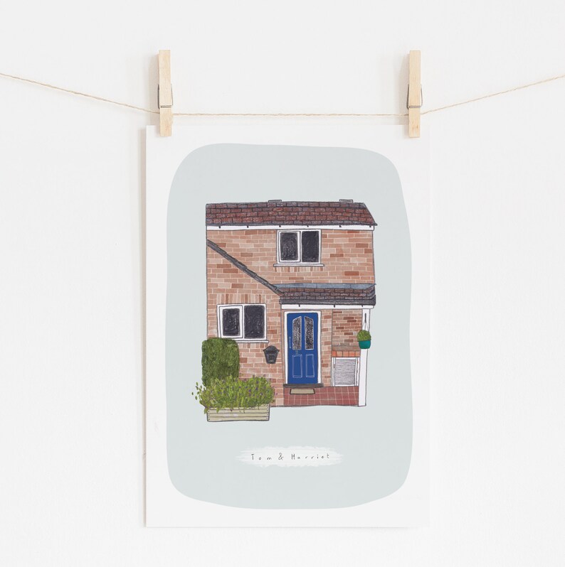 Op de afbeelding: Een handgetekend ontwerp van een bakstenen huis met een blauwe deur en een kleine tuin. Het huis heeft witte versieringen en een bruin dak. De tekst "Tom & Harriet" staat onder het huis.