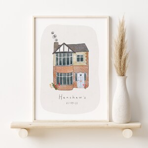 Op de afbeelding: Een aquarel-illustratie van een huis met twee verdiepingen met een bakstenen buitenkant en een witte deur. Het huis heeft een schoorsteen met rook die eruit komt. De illustratie is op een witte achtergrond met de tekst "Henshaw's 21-07-22" onder het huis.