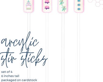 May include: A set of four clear acrylic stir sticks, each 6 inches tall, featuring rectangular tops with colorful illustrations of a pagoda, pink flowers, green birds, and blue floral patterns, presented on cardstock with a cello bag.