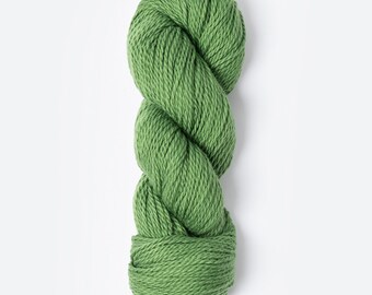 Puede incluir: Un ovillo de lana verde, un material suave y esponjoso para tejer o hacer ganchillo.