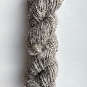 Peut inclure: Une pelote de laine grise. La laine est douce et moelleuse, idéale pour le tricot ou le crochet.