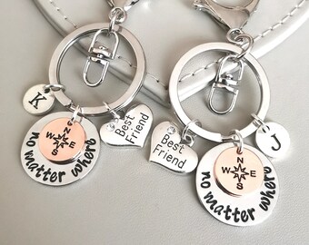 May include: Two silver keychains with charms. One charm has a compass with the words "no matter where" and the other charm has a heart with the words "Best Friend".