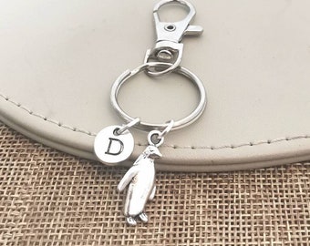 Peut inclure: Porte-clés en argent avec un pingouin en argent et un charme en forme de lettre D. Le porte-clés est attaché à un anneau de clé en argent et un fermoir à homard en argent.