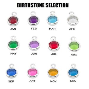 May include: A selection of birthstone charms in different colours, each set in a silver-coloured bezel. The charms are arranged in rows and columns, with the month names labelled below each charm. The text "BIRTHSTONE SELECTION" is at the top.