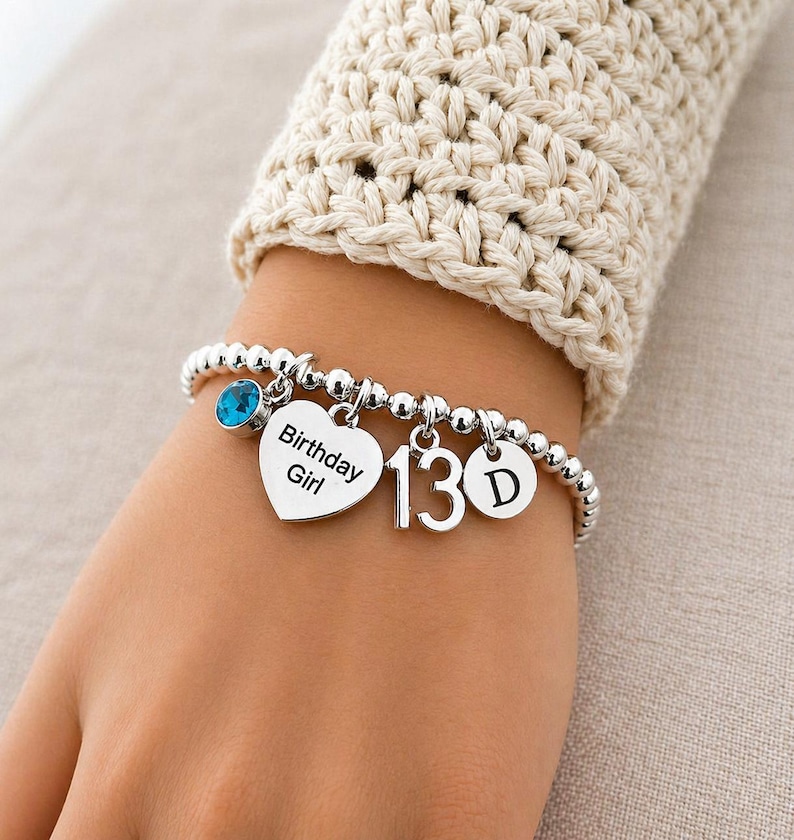 a bracelet that has a charm with the letter of the alphabet and another charm with the number 13