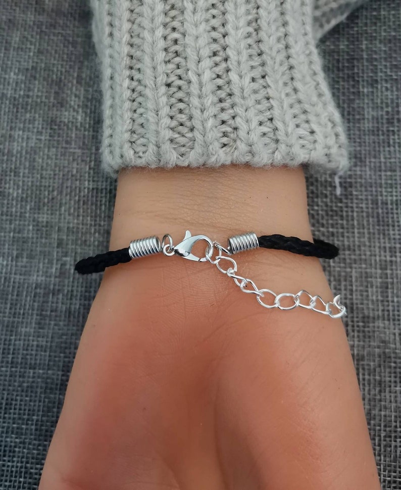 Puede incluir: Un brazalete trenzado negro con un cierre plateado y una extensi&oacute;n de cadena.