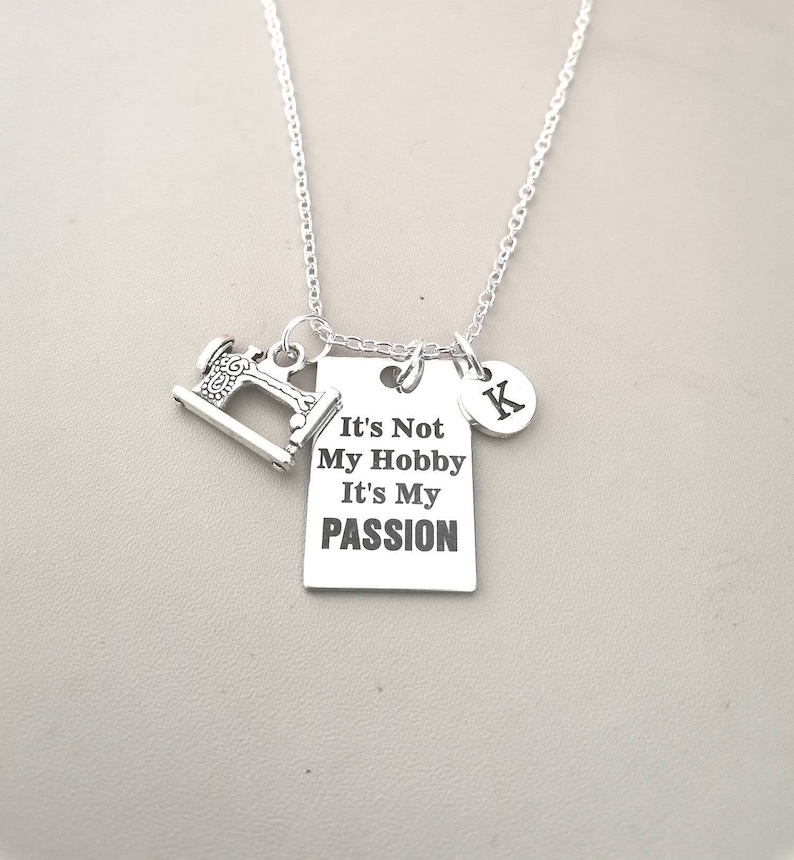 May include: Silver necklace with a sewing machine charm, a tag that reads "It's Not My Hobby It's My Passion", and a charm with the letter K.