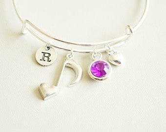 Peut inclure: Bracelet en argent avec un charm en strass violet, un charm en forme de note de musique, un charm en forme de cœur et un charm avec la lettre "R".