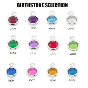 May include: Birthstone selection chart featuring twelve different coloured gemstones, each representing a different month of the year. January is red, February is purple, March is blue, April is clear, May is green, June is lavender, July is red, August is green, September is blue, October is pink, November is orange, and December is blue.