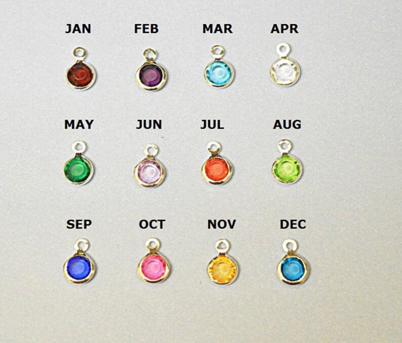 May include: Twelve gold charms with colored gemstones, each charm is labeled with a month of the year, January through December.