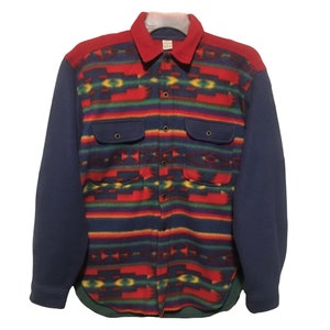 May include: A long-sleeved button-up shirt with a colorful southwestern-style pattern. The shirt has a blue fleece lining on the sleeves and a red collar.